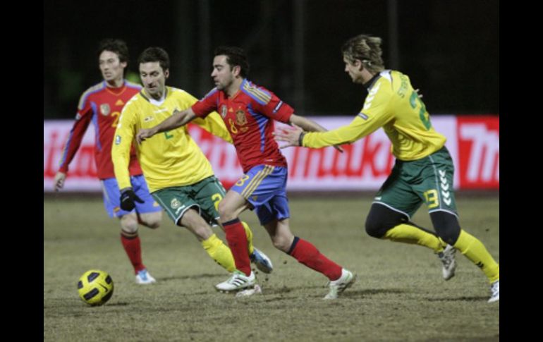 Xavi Hernández, pelea por el balón contra  Deividas Semberas y Marius Stankevicius, en el partido disputado hoy en Kaunas. REUTERS  /