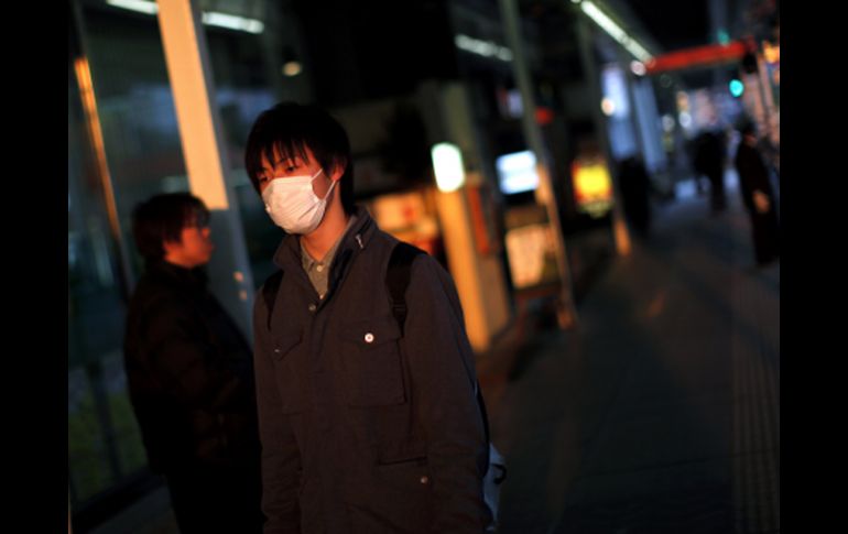 Un joven con cubreboca recorre las afueras de Fukushima. REUTERS  /