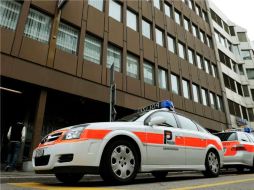 Vehículos de policías junto al acceso del edificio que alberga las oficinas de Swissnuclear en Olten. EFE  /