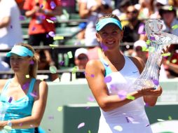 • La tenista bielorrusa, Victoria Azarenka (der.), muestra su trofeo de campeona del Másters de Miami; a su lado Maria Shaparapova. AFP  /