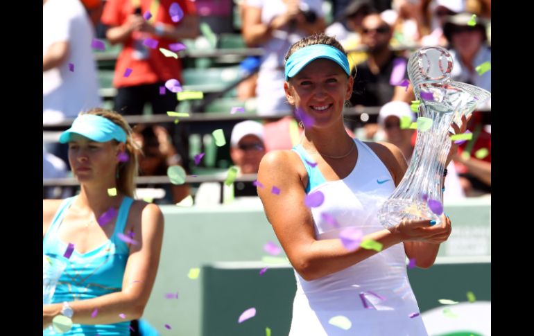 • La tenista bielorrusa, Victoria Azarenka (der.), muestra su trofeo de campeona del Másters de Miami; a su lado Maria Shaparapova. AFP  /