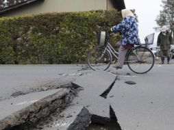 Un ciclista pasea por una carretera dañada por el terremoto en Kurihara, en el Norte de Japón. AP  /