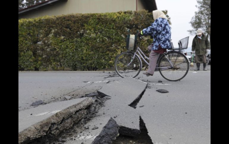 Un ciclista pasea por una carretera dañada por el terremoto en Kurihara, en el Norte de Japón. AP  /