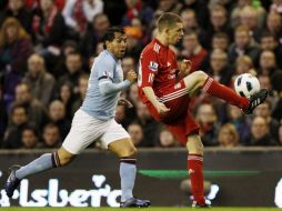 Carlos Tévez, capitán del Manchester City, intenta robar el balón a John Flanagan del Liverpool. REUTERS  /