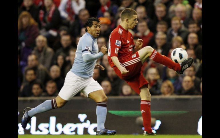 Carlos Tévez, capitán del Manchester City, intenta robar el balón a John Flanagan del Liverpool. REUTERS  /