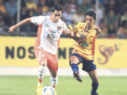 Óscar Razo, de Jaguares, disputa la pelota con el volante del Morelia, Elías Hernández. MEXSPORT  /