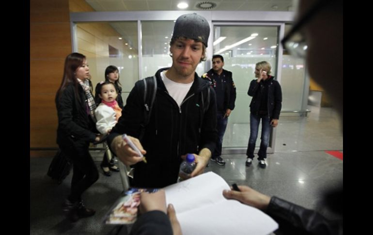 El piloto alemán Sebastian Vettel, de la Escudería Red Bull, firma autógrafos tras su llegada a Shangai. AP  /