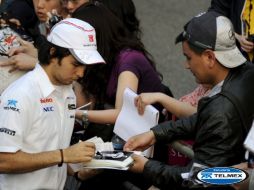 El piloto tapatío de Fórmula Uno, Sergio Perez, firma autógrafos a sus seguidores en el circuito internacional de Shanghai. EFE  /