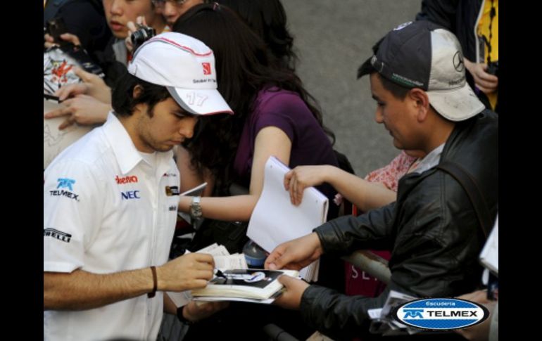 El piloto tapatío de Fórmula Uno, Sergio Perez, firma autógrafos a sus seguidores en el circuito internacional de Shanghai. EFE  /