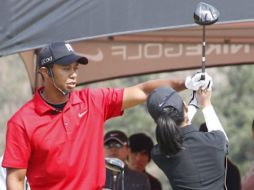 Tiger Woods entrenando a una joven golfista surcoreana. EFE  /