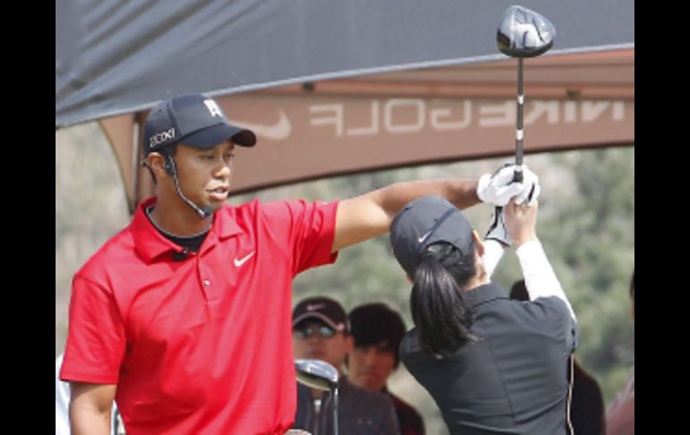 Tiger Woods entrenando a una joven golfista surcoreana. EFE  /