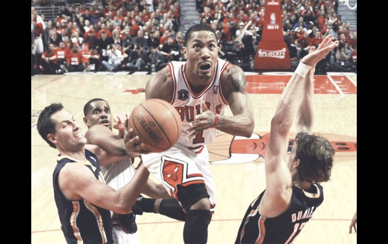 El jugador de los Bulls de Chicago, Derrick Rose, se dirige a la canasta ante la marca de Mike varios rivales. EFE  /