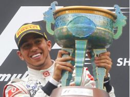 Lewis Hamilton, en lo más alto del podio festejando con su trofeo, el triunfo en el GP de China. EFE  /