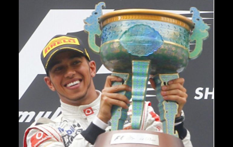 Lewis Hamilton, en lo más alto del podio festejando con su trofeo, el triunfo en el GP de China. EFE  /