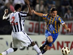 El jugador del San Luis, Ezequiel Cuevas (d) disputa el balón con Pedro Pablo Portocarrero (i) del Libertad de Paraguay. EFE  /