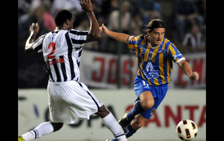 El jugador del San Luis, Ezequiel Cuevas (d) disputa el balón con Pedro Pablo Portocarrero (i) del Libertad de Paraguay. EFE  /