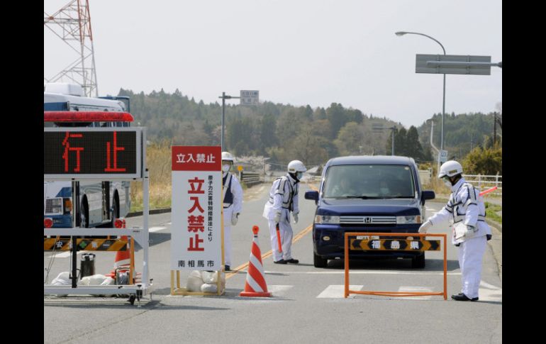 Policías en un punto de revisión en Fukushima, luego de que el gobierno declaró prohibida la zona alrededor de la central. AP  /