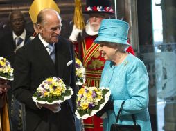 En la misa estuvo acompañada de su esposo el príncipe de  Edimburgo; La reina vestía un abrigo turquesa. EFE  /