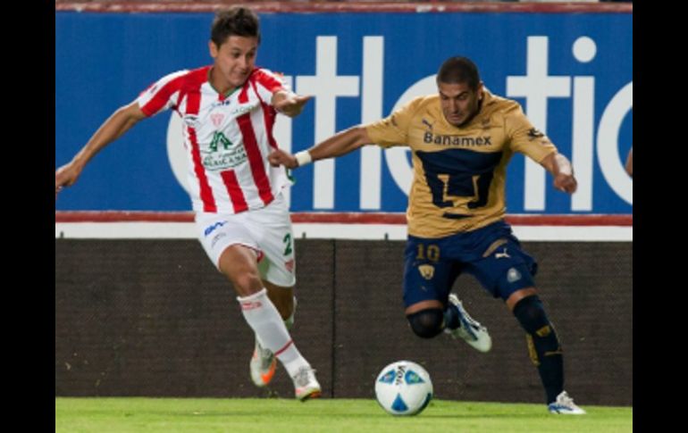 El defensa Arturo Ledesma de Necaxa (i) pelea la pelota con el delantero Martín Bravo de Pumas. EFE  /