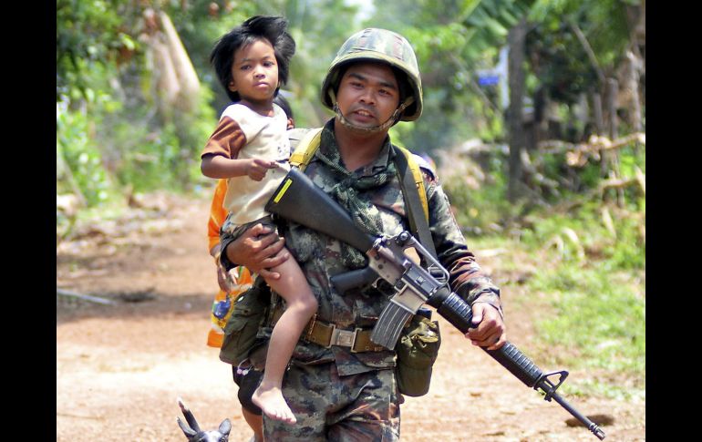 Un soldado rescata a un niño y lo aleja de un lugar donde se combaten el ejército tailandés y el camboyano. EFE  /