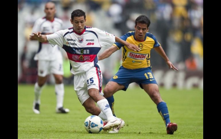 El mediocampista del América, Pavel Pardo, intenta quedarse con el control del balón ante Arturo Muñoz del Atlante. MEXSPORT  /