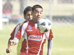 Marco Fabián protege la pelota ante la marca de Omar Esparza (atrás) durante la práctica del “Rebaño”. E. PACHECO  /