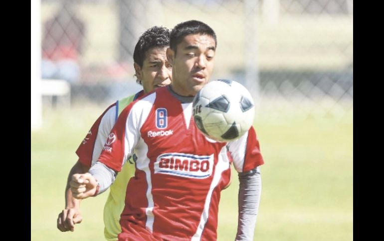 Marco Fabián protege la pelota ante la marca de Omar Esparza (atrás) durante la práctica del “Rebaño”. E. PACHECO  /