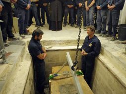 Trabajadores retiran el ataúd de Karol Wojtyla, en la Basílica de San Pedro. AP  /