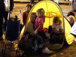 Una mujer y sus hijos se preparan para pasar la noche en una tienda de campaña. REUTERS  /