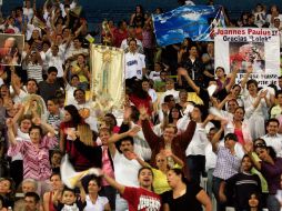 Los fieles católicos realizan cantos marianos populares mientras esperan la celebración eucarística. E. BARRERA  /