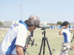 Ángel Ramírez observa su flecha, mientras que Judith Ramírez ejecuta su disparo. ESPECIAL  /