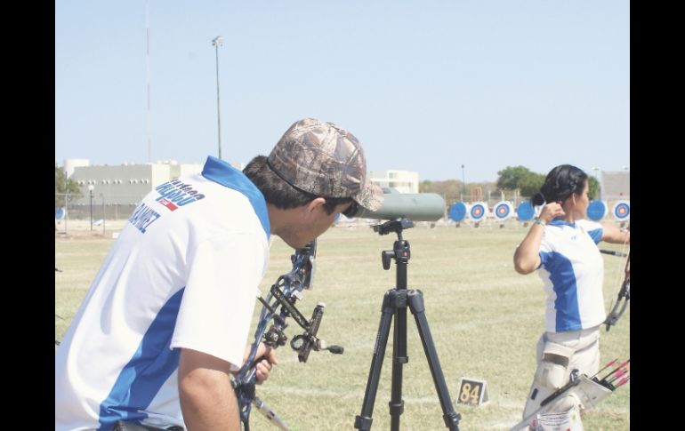 Ángel Ramírez observa su flecha, mientras que Judith Ramírez ejecuta su disparo. ESPECIAL  /