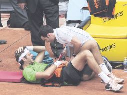 Juan Martín del Potro yace adolorido en la arcilla y es atendido por el médico del torneo tras finalizar el primer set. REUTERS  /