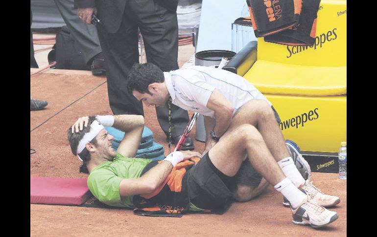 Juan Martín del Potro yace adolorido en la arcilla y es atendido por el médico del torneo tras finalizar el primer set. REUTERS  /