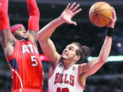 Joakim Noah de los Bulls de Chicago, manda un tiro a la canasta con la marca del jugador de Atlanta, Josh Smith. REUTERS  /