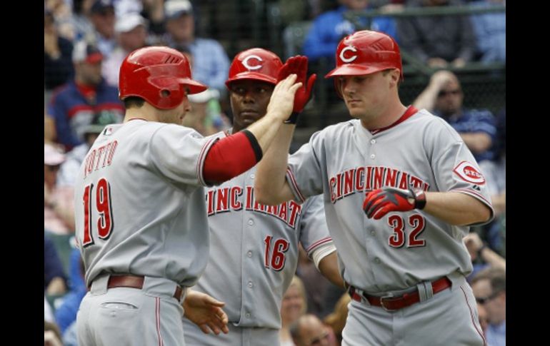 Los jugadores, Jay Bruce, Joey Votto y Edgar Rentería, festejan la victoria sobre los Cachorros de Chicago. AP  /