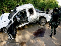 Soldados tailandeses inspeccionan un vehículo militar tras ser alcanzado por la explosión. EFE  /