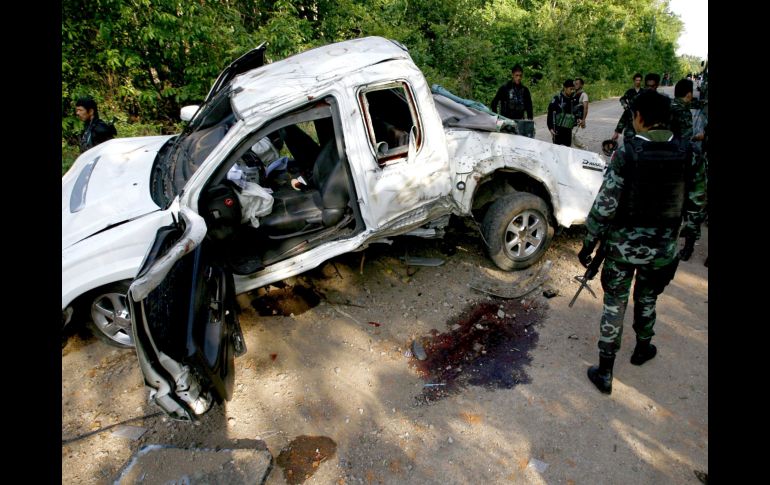 Soldados tailandeses inspeccionan un vehículo militar tras ser alcanzado por la explosión. EFE  /