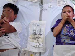 Dos niños reaccionan mientras son circuncidados durante una ceremonia colectiva. EFE  /