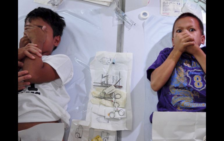 Dos niños reaccionan mientras son circuncidados durante una ceremonia colectiva. EFE  /