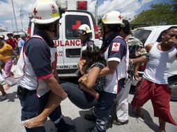 Socorristas de la Cruz Roja brindan atención a una familiar de un interno. REUTERS  /