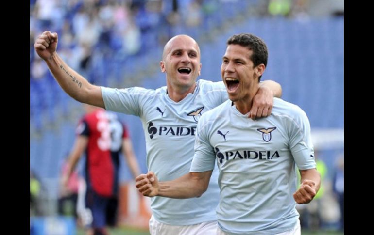 El brasileño, Hernanes, celebra con su compañero del Lazio tras la anotación ante Genoa. AP  /