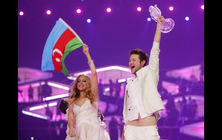 Eldar Kasimov y Nigyar Djamal ondean la bandera azerbaiyana mientras sostienen el premio del concurso musical. EFE  /