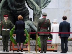 La reina Isabel II y la presidenta Mary Mc Aleese depositan una corona de flores durante su visita al Jardín del Recuerdo. EFE  /