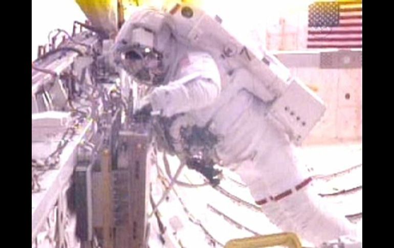 Greg Chamitoff recupera un experimento de la bodega de carga durante la caminata espacial. REUTERS  /