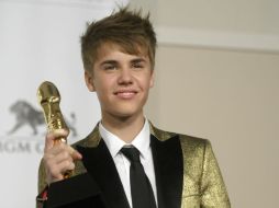 Justin Bieber exhibe el premio ante los fotógrafos. AP  /