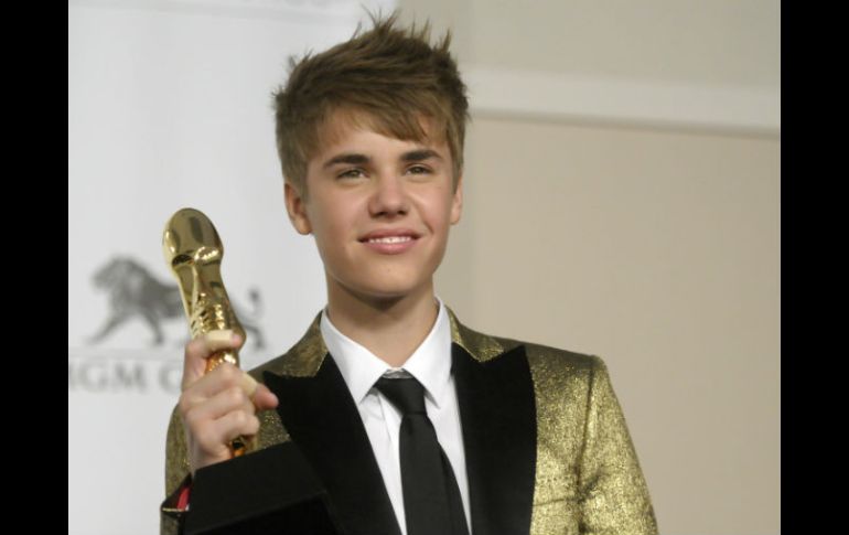 Justin Bieber exhibe el premio ante los fotógrafos. AP  /