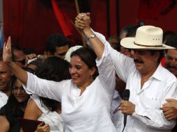 Manuel Zelaya y su esposa Xiomara Castro de Zelaya saludan a sus simpatizantes. AP  /