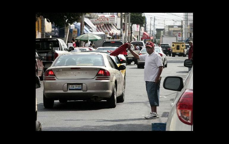 La cuota que pagan conductores a “franeleros” por estacionarse en la vía pública, es el acto de corrupción más alto en Jalisco. ARCHIVO  /