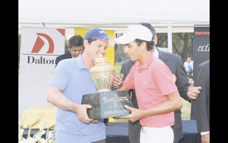 El campeón del año pasado, Jonathan Arce (izq.), le hace entrega del trofeo al nuevo monarca, David Faraudo. ESPECIAL  /